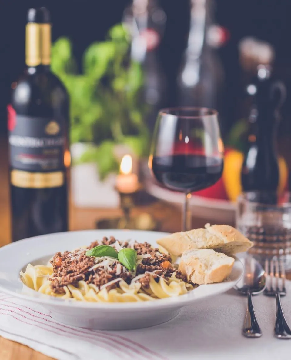 A candlelit table set with wine and the evening's first course