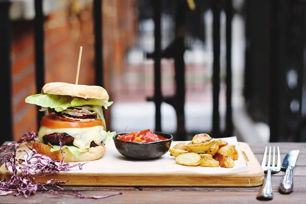 The classic burger with crispy potatoes and house salsa on a board